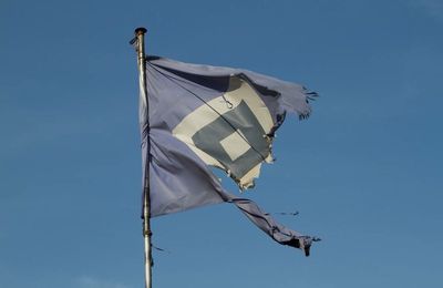 Low angle view of flag against clear blue sky