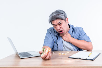 Man using laptop on table against white background