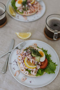 Prawn sandwiches with eggs and lemon on table