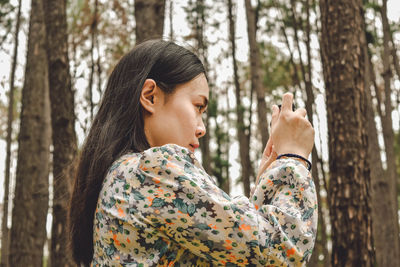 Young woman looking away in forest