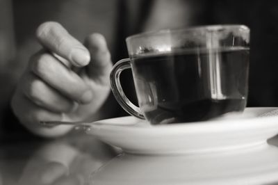 Close-up of cropped hand holding coffee cup