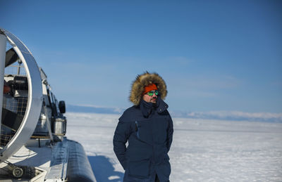 Rear view of woman standing on snow covered landscape