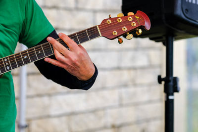 Midsection of man playing guitar