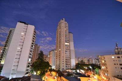 Illuminated buildings in city against sky at night