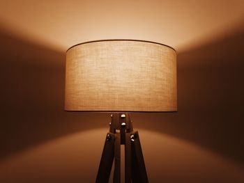 Close-up of illuminated lamp against wall at home