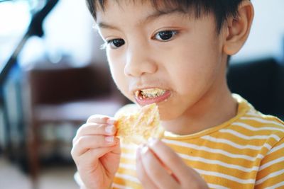 Close-up portrait of boy eating food