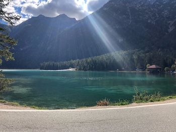 Scenic view of lake by mountains against sky