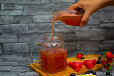 Close-up of hand holding drink on table