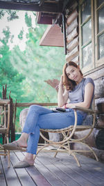 Full length of woman sitting on chair in yard