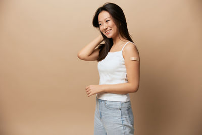 Young woman standing against wall