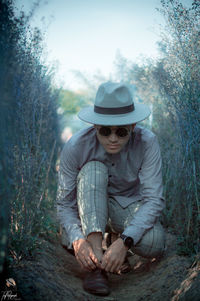 Midsection of man wearing hat against trees