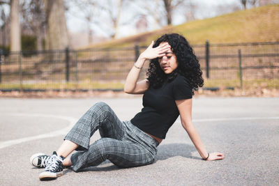 Young woman sitting on road