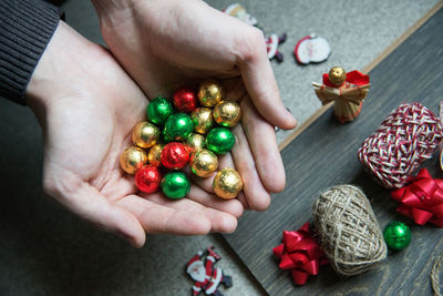 Cropped hand of woman holding christmas decorations