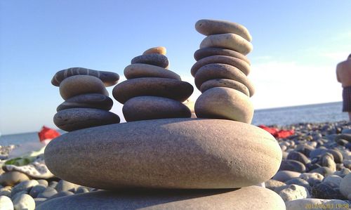 Stack of stones on beach against sky
