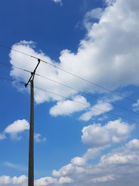 Low angle view of birds flying against blue sky