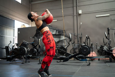 Low section of man exercising with dumbbells in gym