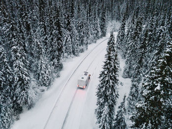 High angle view of snow covered road amidst trees
