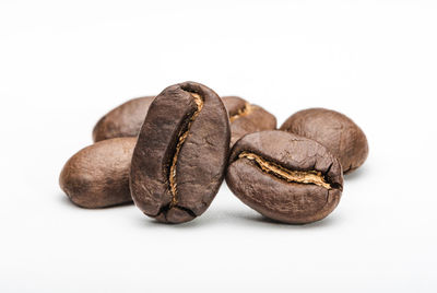 Close-up of roasted coffee beans against white background