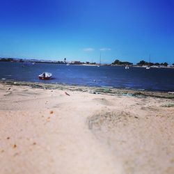 Scenic view of beach against clear blue sky