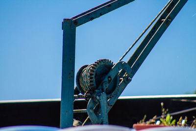 Close-up of machine part against clear blue sky
