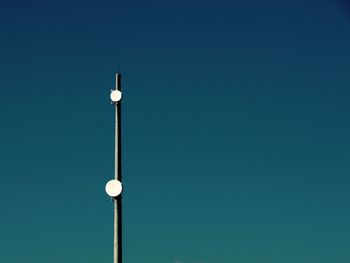 Low angle view of communications tower against clear blue sky