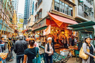 People on street amidst buildings in city