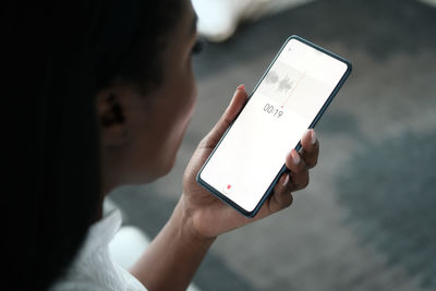 Close-up of businesswoman talking on smart phone sitting at home