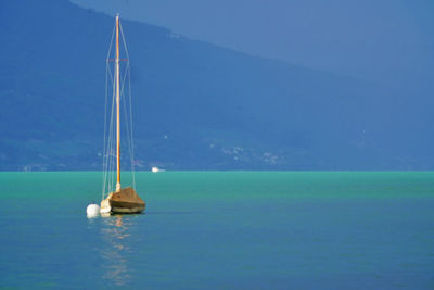 Sailboat in sea against blue sky