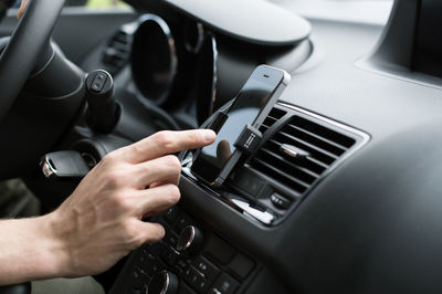 Male hand using gps on smart phone in car