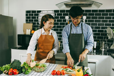 Friends standing by people in kitchen