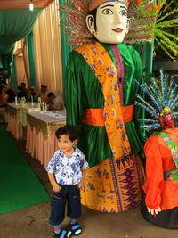 Full length of a boy standing against wall