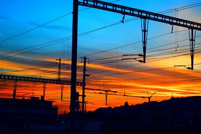 Silhouette suspension bridge against sky during sunset