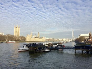 Boats in river with city in background