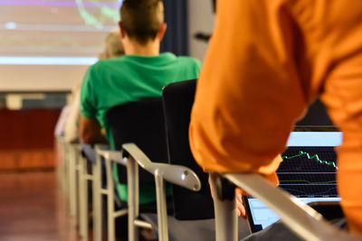 Rear view of people sitting on chairs during seminar