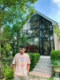 Portrait of woman standing against trees