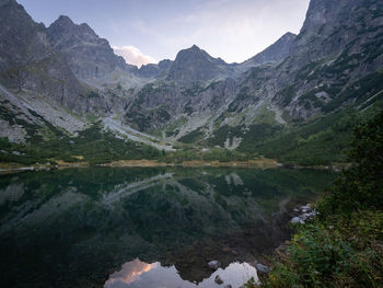 Beautiful alpine lake surrounded by mountains during colorful sunset, europe, slovakia