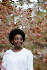 Smiling woman standing outdoors during autumn