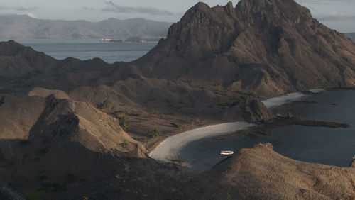 Scenic view of sea and mountains against sky