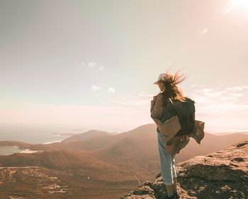 Horse standing in front of mountain range against sky