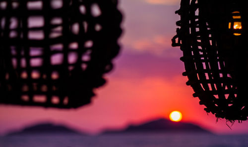 Close-up of silhouette illuminated building against sky at sunset