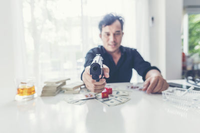 Portrait of man photographing on table