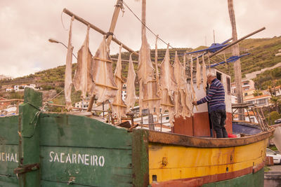 Man standing on boat against sky