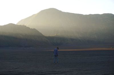 Man standing on mountain against sky