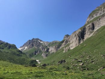 Scenic view of mountains against clear blue sky