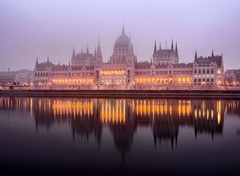 Reflection of buildings in city at dusk