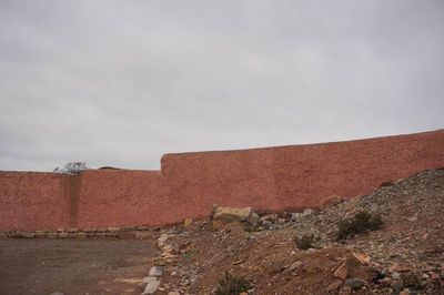 View of wall and land against sky