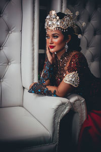 Portrait of a smiling young woman sitting on sofa