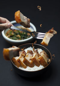 Close-up of hand holding food in plate