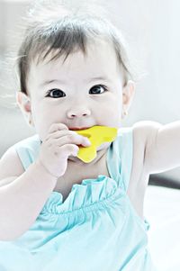 Portrait of cute baby girl eating alphabet a