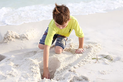 Rear view of boy playing on beach
